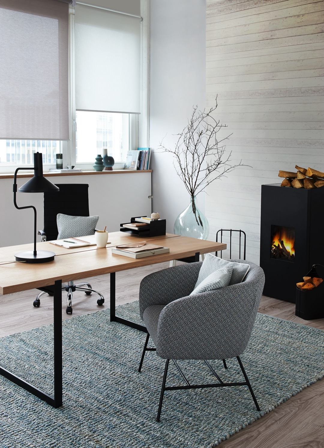 Deco Team setzt das Thema Home Office als Hybrid-Raum um, in dem die Grenzen zwischen Esszimmer und Arbeitsbereich fließend sind. Die Idee ist, das Esszimmer tagsüber zum Home Office zu machen. Die feine Gemütlichkeit wird durch die Auswahl heller Holz-, Creme- und Grautöne betont, die ein klares, "aufgeräumtes" Ambiente schaffen, in dem man sich wohlfühlen und zugleich konzentriert arbeiten kann. Mit Jalousien und Rollos von Erfal wird der Lichteinfall reguliert. Das sorgt für ausreichend Tageslicht und blendfreies Arbeiten. Der gemütliche Sessel ist mit einem grafisch gemusterten Bezugsstoff aus der Kollektion Höpke Active Line Sensation bezogen, der mit einer speziellen Fleckschutzausrüstung kommt. Der handgewebte Schurwollteppich City Denver verleiht dem Raum zusätzlich textilen Touch.<br><br>Rollos: Erfal<br>Teppich: Haro Teppiche by Paulig<br>Möbelstoff: Höpke<br>Foto: Deco Team Deco Team Trends 2021 Chalet Style – natürlich und gemütlich